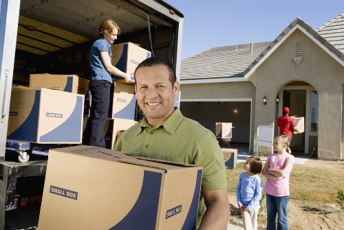 House movers carrying furniture through a residential property in Watford